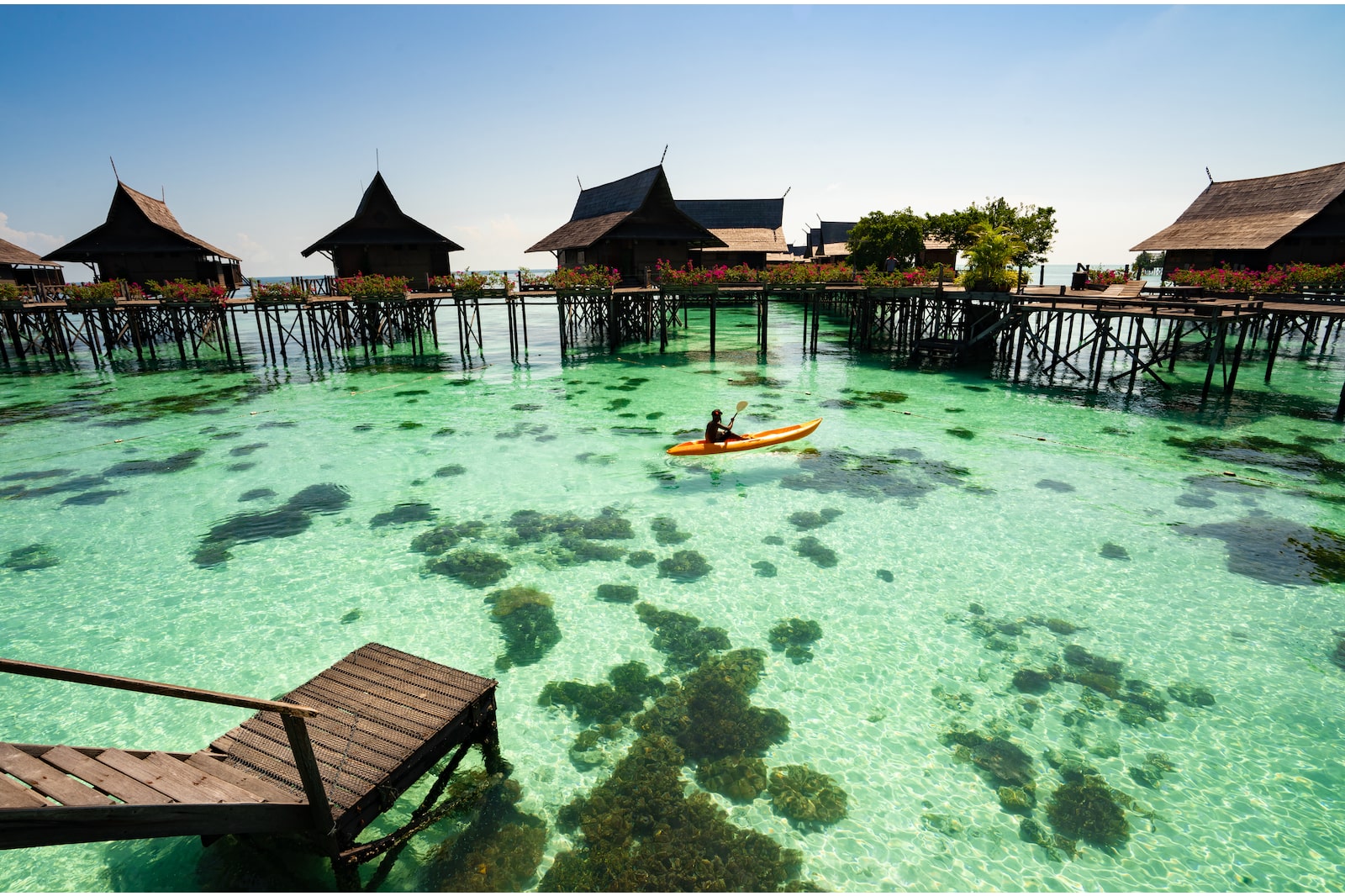 Transparent waters by island huts in Pulau Sipadan