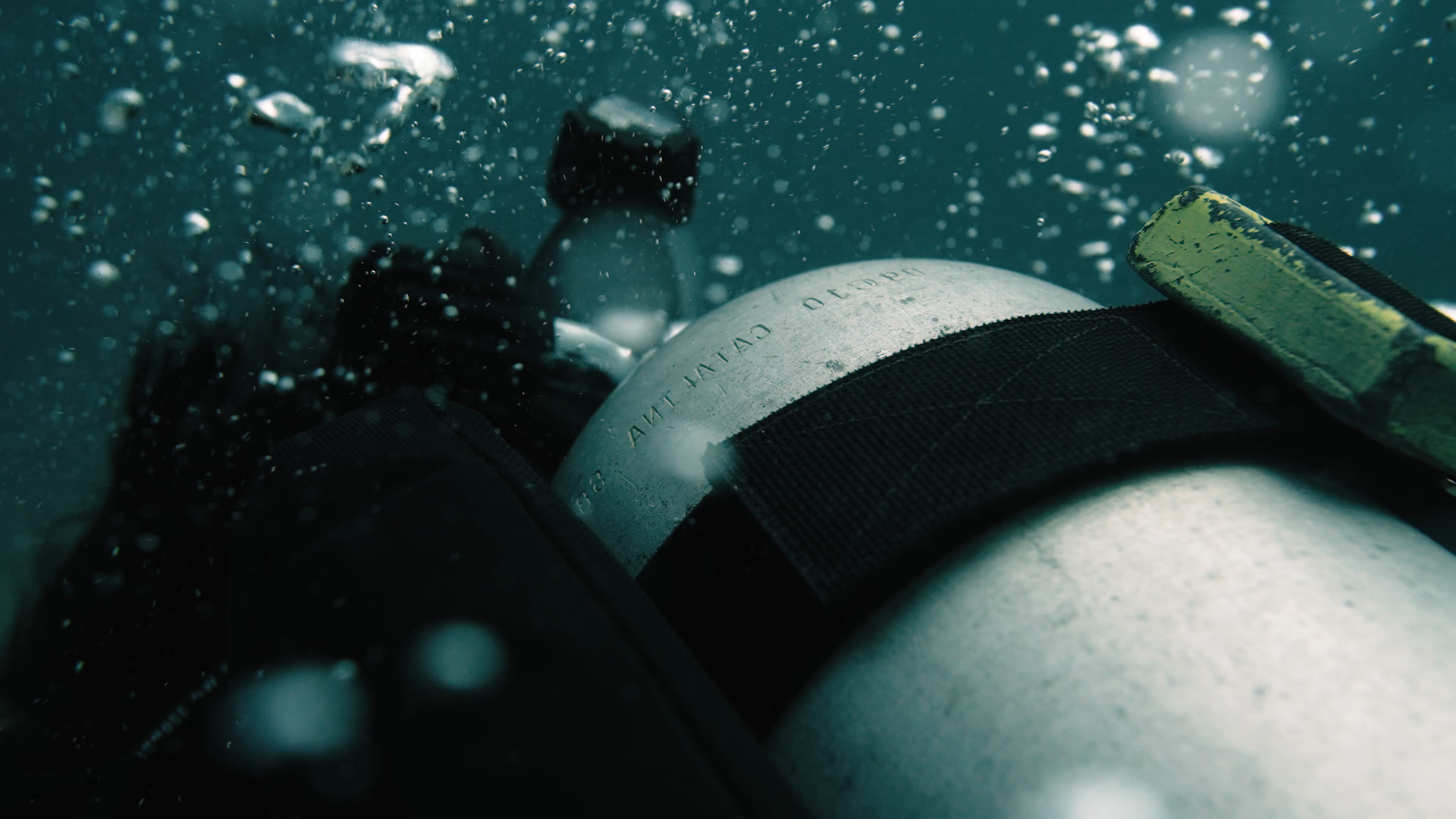 Close-up of a diver's oxygen tank with air bubbles around